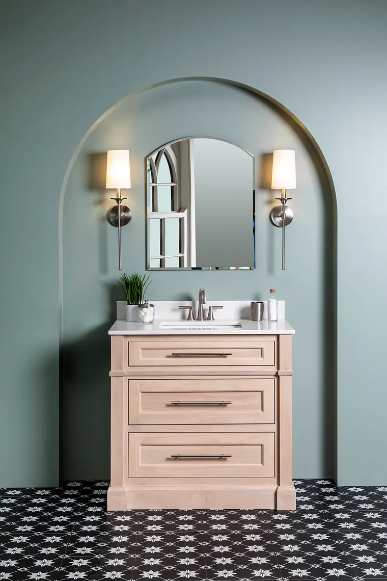 Blush vanity framed by an arched sage niche