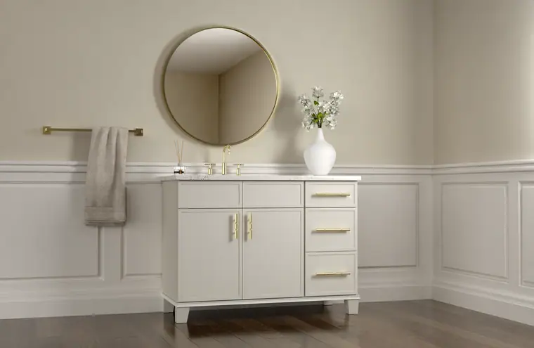 Cream Fabuwood vanity with wainscoting and a round mirror