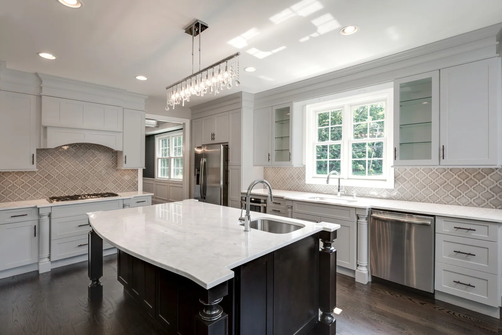 A bright white kitchen with a large center island and plenty of natural light