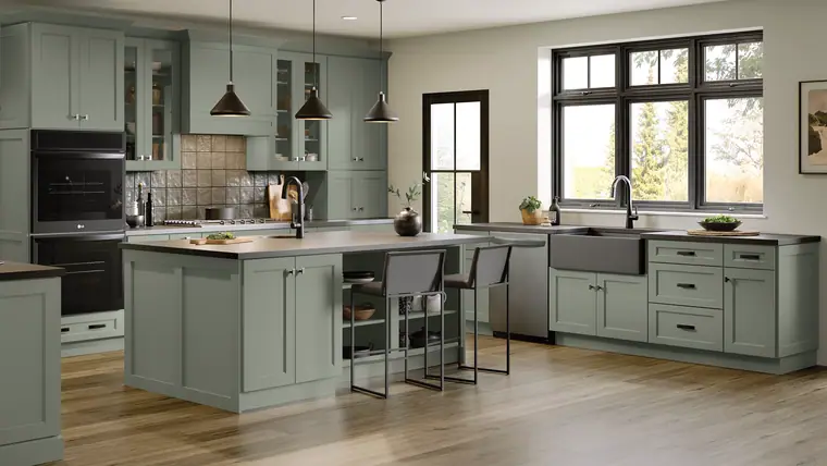 Sage-green farmhouse kitchen with a black apron sink