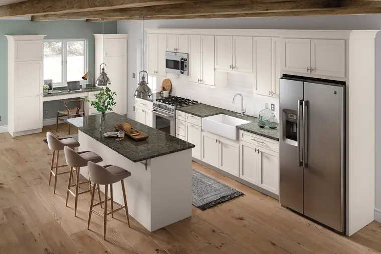 White farmhouse kitchen with a green granite island and exposed beams